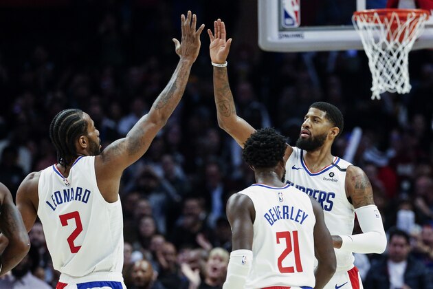 FILE - In this Monday, Feb. 3, 2020, file photo, Los Angeles Clippers' Paul George, right, celebrates with teammate Kawhi Leonard (2) after scoring against the San Antonio Spurs during the second half of an NBA basketball game, in Los Angeles. Leonard and George are healthy at the same time to start the 2020-21 season, and thatâ€™s given the Clippers a renewed sense of optimism. (AP Photo/Ringo H.W. Chiu, File)