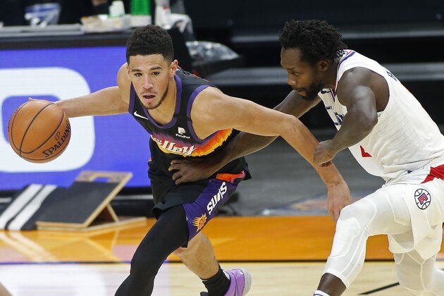 Phoenix Suns guard Devin Booker, left, drives as Los Angeles Clippers guard Patrick Beverley defends during the second half of an NBA basketball game Sunday, Jan. 3, 2021, in Phoenix. (AP Photo/Ralph Freso)