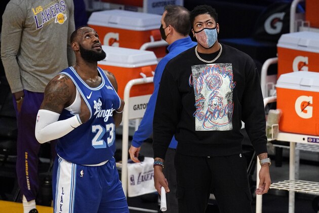 Los Angeles Lakers forward LeBron James, left, talks with Anthony Davis during the first half of an NBA basketball game against the Minnesota Timberwolves Tuesday, March 16, 2021, in Los Angeles. (AP Photo/Mark J. Terrill)
