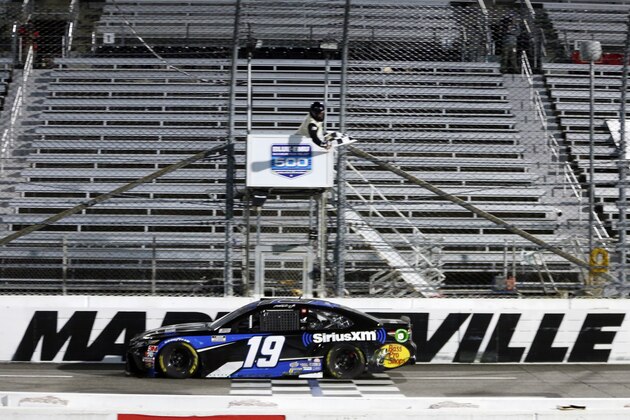 Martin Truex Jr. (19) takes the checkered flag to win a NASCAR Cup Series auto race Wednesday, June 10, 2020, in Martinsville, Va. (AP Photo/Steve Helber)