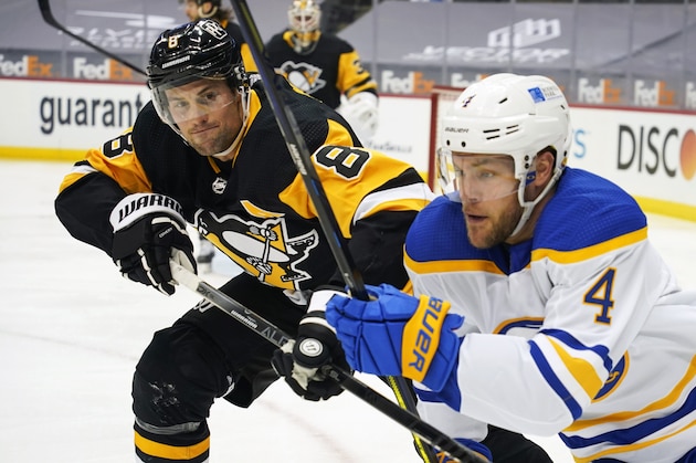 Pittsburgh Penguins' Brian Dumoulin (8) defunds as Buffalo Sabres' Taylor Hall (4) pursues the puck during the second period of an NHL hockey game, Wednesday, March 24, 2021, in Pittsburgh. (AP Photo/Keith Srakocic)