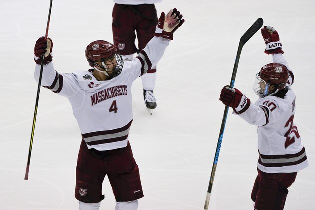 Massachusetts's Matthew Kessel (4) celebrates with Oliver Chau (20) after scoring against St. Cloud State during the first period of the NCAA men's Frozen Four hockey championship game in Pittsburgh, Saturday, April 10, 2021. (AP Photo/Keith Srakocic)