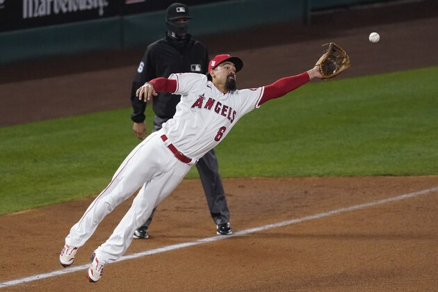 Los Angeles Angels third baseman Anthony Rendon (6) is short of catching a throw to third from relief pitcher Raisel Iglesias during the ninth inning of a baseball game against the Chicago White Sox Sunday, April 4, 2021, in Anaheim, Calif. Chicago White Sox' Nick Madrigal scored. (AP Photo/Ashley Landis)