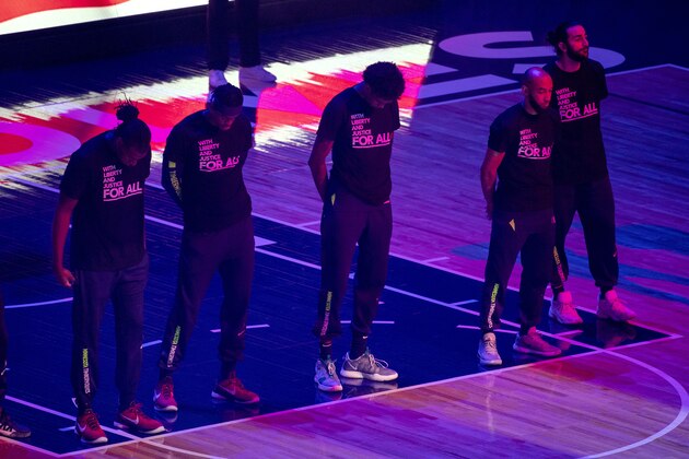 Members of the Minnesota Timberwolves, pictured, and the Brooklyn Nets wear T-shirts that read
