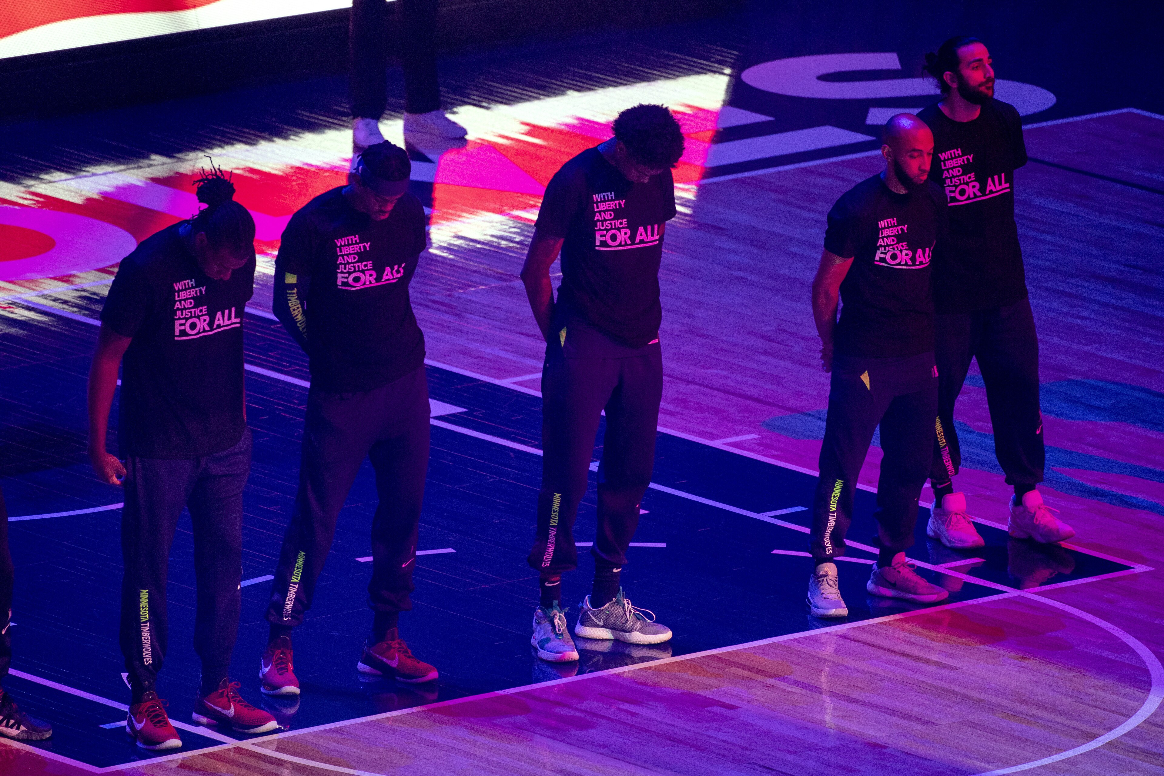 Members of the Minnesota Timberwolves, pictured, and the Brooklyn Nets wear T-shirts that read
