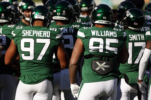 New York Jets defensive end Nathan Shepherd (97) with the words 'End Racism' seen on his helmet next to New York Jets defensive tackle Quinnen Williams (95) before an NFL football game against the Miami Dolphins, Sunday, Nov. 29, 2020, in East Rutherford, N.J. (AP Photo/Adam Hunger)