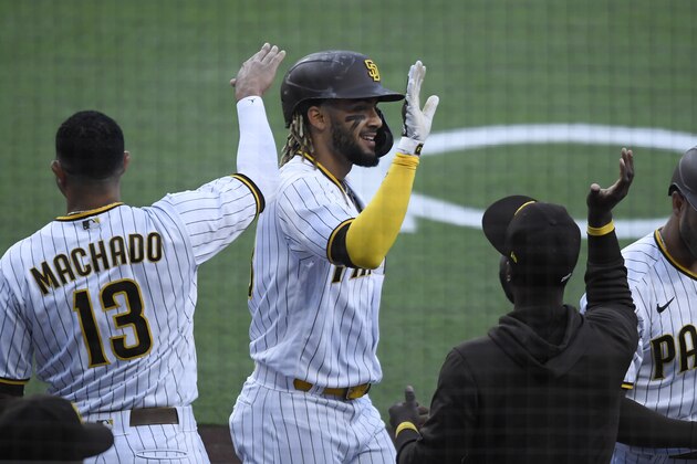 San Diego Padres shortstop Fernando Tatis Jr., center, and Manny Machado play during a baseball game against the Arizona Diamondbacks Saturday, April 3, 2021, in San Diego. (AP Photo/Denis Poroy)