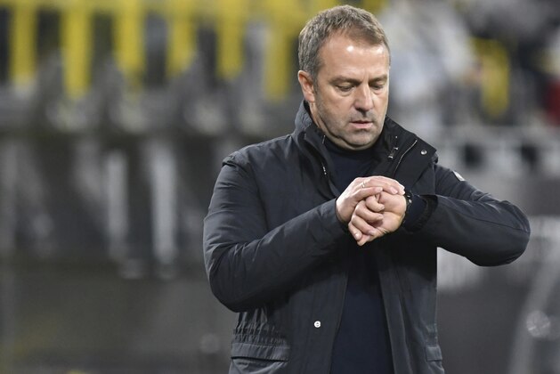 Munich coach Hansi Flick looks at his watch during the German Bundesliga soccer match between Borussia Dortmund and Bayern Munich at Signal Iduna Park, in Dortmund, Germany, Saturday, Nov. 7, 2020. (Bernd Thissen/Pool via AP)
