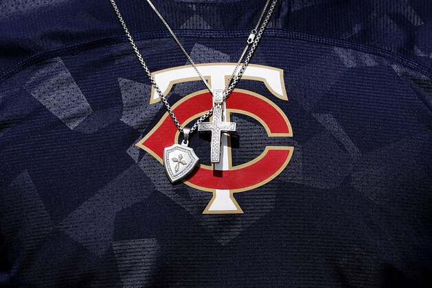 Jewelry hangs in front of the Minnesota Twins logo on the shirt of player Byron Buxton as he works out at baseball spring training in Fort Myers, Fla., Thursday, Feb. 16, 2017. (AP Photo/David Goldman)
