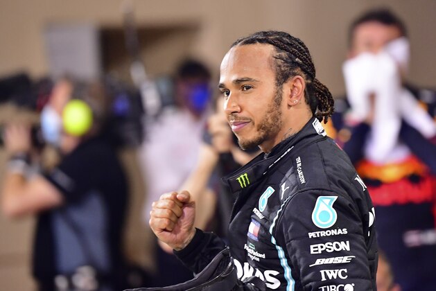 FILE - In this Sunday, Nov. 29, 2020 file photo Mercedes driver Lewis Hamilton of Britain celebrates after wining the Formula One race in Bahrain International Circuit in Sakhir, Bahrain. World champion Lewis Hamilton tested positive for COVID-19 and will miss the Sakhir Grand Prix this weekend, his Mercedes-AMG Petronas F1 Team said Tuesday Dec. 1, 2020. (Giuseppe Cacace, Pool via AP, File)
