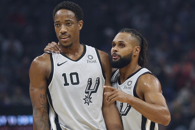 San Antonio Spurs guard Patty Mills, right, talks with teammate DeMar DeRozan during the second quarter of an NBA basketball game against the Sacramento Kings Monday, Nov. 12, 2018, in Sacramento, Calif.(AP Photo/Rich Pedroncelli)