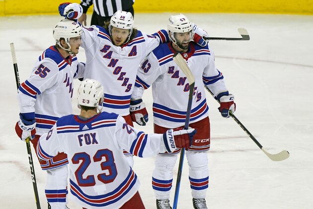 New York Rangers left wing Artemi Panarin (10) celebrates with defensemen Adam Fox (23), Ryan Lindgren (55) and center Colin Blackwell (43) after scoring the third period of an NHL hockey game against the New Jersey Devils, Tuesday, April 13, 2021, in Newark, N.J. (AP Photo/Kathy Willens)