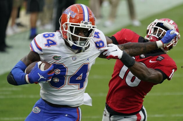 FILE - Florida tight end Kyle Pitts (84) tires to get past Georgia defensive back Lewis Cine (16) after a reception during the first half of an NCAA college football game in Jacksonville, Fla., in this Saturday, Nov. 7, 2020, file photo. Kyle Pitts is arguably the most dynamic playmaker in the NFL draft, a versatile tight end who will try to impress league executives in person during Florida's pro day Wednesday, March 31, 2021.  (AP Photo/John Raoux, File)
