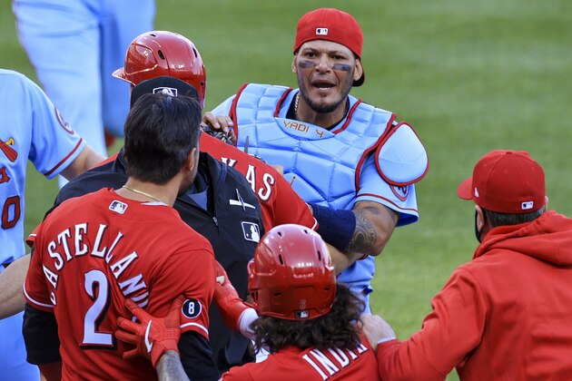 St. Louis Cardinals' Yadier Molina, center back, exchanges words with Cincinnati Reds' Nick Castellanos during a baseball game in Cincinnati, Saturday, April 3, 2021. The Reds won 9-6. (AP Photo/Aaron Doster)