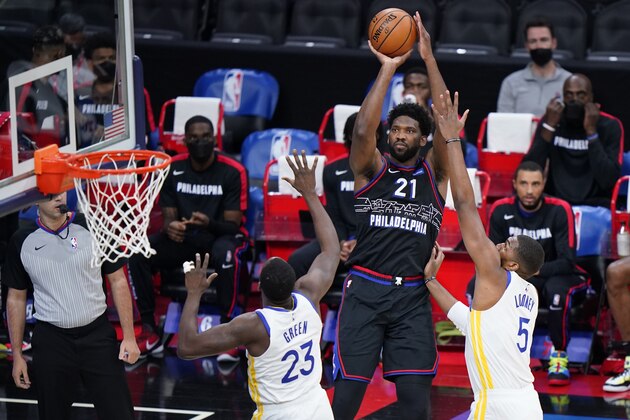 Philadelphia 76ers' Joel Embiid (21) goes up for a shot against Golden State Warriors' Draymond Green (23) and Kevon Looney (5) during the first half of an NBA basketball game, Monday, April 19, 2021, in Philadelphia. (AP Photo/Matt Slocum)