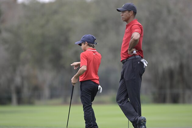 Tiger Woods, right, and his son Charlie wait to putt on the 11th green during the final round of the PNC Championship golf tournament, Sunday, Dec. 20, 2020, in Orlando, Fla. (AP Photo/Phelan M. Ebenhack)