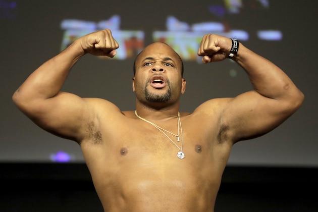 Daniel Cormier reacts while posing atop a scale prior to his heavyweight mixed martial arts bout against Derrick Lewis during the weigh-ins ahead of UFC 230, Friday, Nov. 2, 2018, at Madison Square Garden in New York. (AP Photo/Julio Cortez)