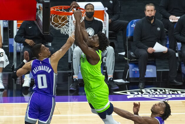 Minnesota Timberwolves forward Anthony Edwards (1) dunks as Sacramento Kings guard Tyrese Haliburton (0) defends during the first quarter of an NBA basketball game in Sacramento, Calif., Tuesday, April 20, 2021. (AP Photo/Randall Benton)