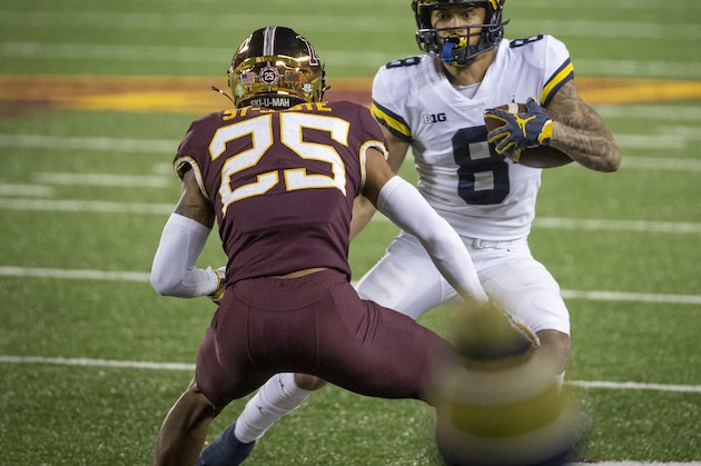 Michigan wide receiver Ronnie Bell (8) looks to get past Minnesota defensive back Benjamin St-Juste (25) in the second quarter of an NCAA college football game Saturday, Oct. 24, 2020, in Minneapolis. Michigan won 49-24. (AP Photo/Bruce Kluckhohn)