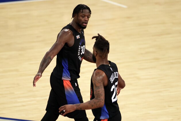 New York Knicks forward Julius Randle, left, reacts with forward Reggie Bullock, right, during the second half of an NBA basketball game against the New Orleans Pelicans on Sunday, April 18, 2021, in New York.  (AP Photo/Adam Hunger, Pool)