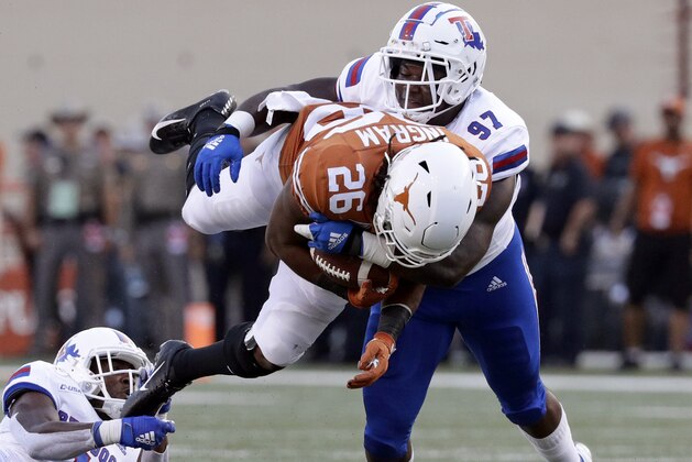 Texas running back Keaontay Ingram (26) is up ended by Louisiana Tech safety L'Jarius Sneed (1) and defensive end Milton Williams (97) on a run during the first half of an NCAA college football game, Saturday, Aug. 31, 2019, in Austin, Texas. (AP Photo/Eric Gay)