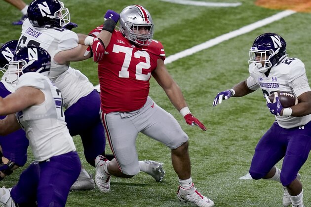 Northwestern running back Cam Porter (20) runs with the ball as Ohio State defensive tackle Tommy Togiai (72) defends during the first half of the Big Ten championship NCAA college football game, Saturday, Dec. 19, 2020, in Indianapolis. (AP Photo/Darron Cummings)