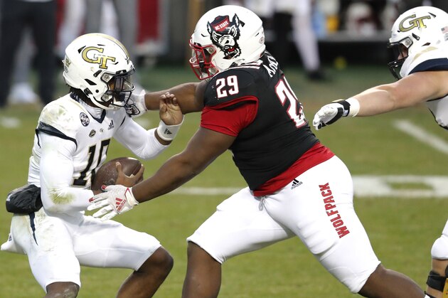 Georgia Tech quarterback Jeff Sims (10) escapes from North Carolina State defensive tackle Alim McNeill (29)  during the first half of an NCAA college football game in Raleigh, N.C., Saturday, Dec. 5, 2020. (Ethan Hyman/The News & Observer via AP, Pool)
