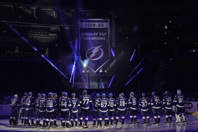 Tampa Bay Lightning players look on as their 2019-2020 Stanley Cup Champions banner is revealed before an NHL hockey game against the Chicago Blackhawks Wednesday, Jan. 13, 2021, in Tampa, Fla. (AP Photo/Chris O'Meara)