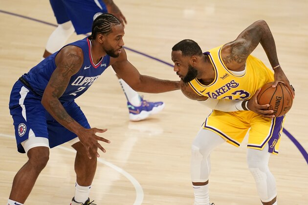 Los Angeles Lakers forward LeBron James, right, is defended by Los Angeles Clippers forward Kawhi Leonard during the first half of an NBA basketball game Tuesday, Dec. 22, 2020, in Los Angeles. (AP Photo/Marcio Jose Sanchez)