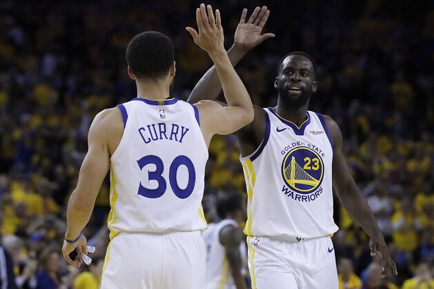 Golden State Warriors' Draymond Green, right, celebrates with Stephen Curry (30) during the final minutes of Game 1 of the team's NBA basketball playoffs Western Conference finals against the Portland Trail Blazers on Tuesday, May 14, 2019, in Oakland, Calif. (AP Photo/Ben Margot)