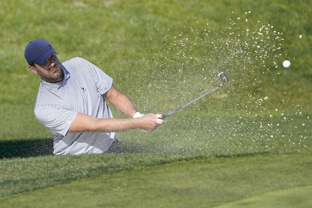 Tony Romo hits a ball out of the bunker on the 17th green of the Spyglass Hill Golf Course during the first round of the AT&T Pebble Beach National Pro-Am golf tournament Thursday, Feb. 6, 2020, in Pebble Beach, Calif. (AP Photo/Tony Avelar)