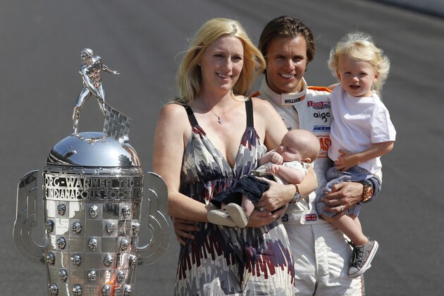 FILE - In this May 30, 2011 file photo, IndyCar driver Dan Wheldon, of England, poses with his family, wife Susie, left, holding Oliver, and Sebastian, right, next to the Borg-Warner Trophy during the traditional winners photo of the Indianapolis 500 auto race champion on the start/finish line at the Indianapolis Motor Speedway in Indianapolis. Seven months after the accident that killed her husband, Wheldon heads to the Indianapolis 500, for ceremonies honoring the defending race winner. She'll arrive Thursday night and spend the weekend, accompanied by her two sons, who were present for their dad's surprise win last year, but isn't sure if she'll attend Sunday's race.   (AP Photo/Michael Conroy, File)