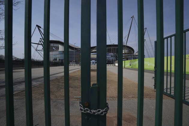 FILE - In this file photo dated Thursday, April 9, 2020, gates stand locked outside the closed English Premier League soccer Manchester City Etihad Stadium, in Manchester, northern England.  Guidance for sports bodies was published by the government on Saturday May 30, 2020, as COVID-19 lockdown restrictions are being eased further, allowing Sports events to resume in England from upcoming Monday, without any spectators and providing they comply with the government's coronavirus protocols. (AP Photo/Jon Super, FILE)