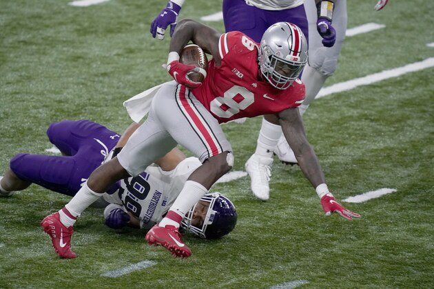 Ohio State running back Trey Sermon (8) runs with the ball past Northwestern defensive end Earnest Brown IV (99) during the second half of the Big Ten championship NCAA college football game, Saturday, Dec. 19, 2020, in Indianapolis. (AP Photo/Darron Cummings)