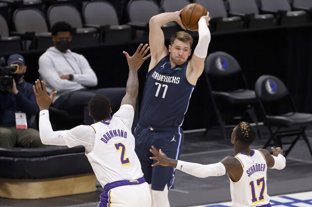 Dallas Mavericks guard Luka Doncic (77) looks to pass over Los Angeles Lakers center Andre Drummond (2) and guard Dennis Schroeder (17) during the first half of an NBA basketball game Saturday, April 24, 2021, in Dallas. (AP Photo/Ron Jenkins)