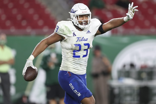 FILE - Tulsa linebacker Zaven Collins (23) celebrates after scoring a touchdown during an NCAA football game in Tampa, Fla., in this Oct. 23, 2020, file photo. Zaven Collins is a small-town player with big-time talent. He was overlooked after a stellar high school career in Hominy, Okla., a town with about 3,500 people. He’s got the nation’s attention now -- the 6-foot-4, 260-pound linebacker is a finalist for the Butkus and Nagurski Awards.  (AP Photo/Mark LoMoglio, File)