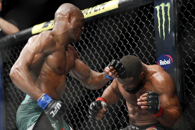 Kamaru Usman, left, hits Tyron Woodley during a welterweight mixed martial arts title fight at UFC 235, Saturday, March 2, 2019, in Las Vegas. (AP Photo/John Locher)
