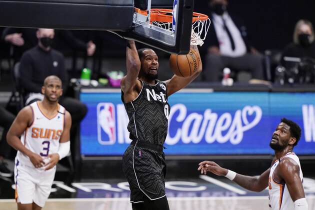 Phoenix Suns guard Chris Paul, left, and Suns center Deandre Ayton, right, watch as Brooklyn Nets forward Kevin Durant (7) dunks unopposed the third quarter of an NBA basketball game, Sunday, April 25, 2021, in New York. (AP Photo/Kathy Willens)