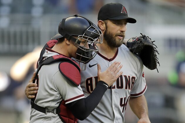 Arizona Diamondbacks pitcher Madison Bumgarner, right, is congratulated by catcher Carson Kelly after pitching a seven-inning no-hitter against the Atlanta Braves, at the end of the second baseball game of a doubleheader, Sunday, April 25, 2021, in Atlanta. (AP Photo/Ben Margot)