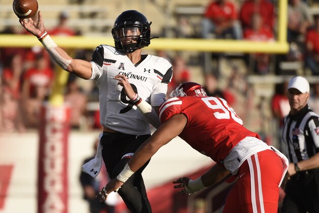 Cincinnati quarterback Desmond Ridder, left, throws a pass as Houston defensive lineman Payton Turner applies defensive pressure during the second half of an NCAA college football game, Saturday, Oct. 12, 2019, in Houston. (AP Photo/Eric Christian Smith)