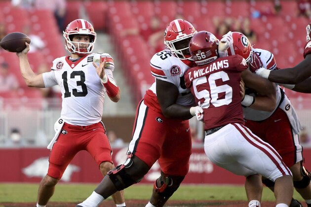 Georgia quarterback Stetson Bennett (13) throws a pass against Arkansas while offensive lineman Trey Hill (55) blocks during the second half of an NCAA college football game in Fayetteville, Ark., Saturday, Sept. 26, 2020. (AP Photo/Michael Woods)