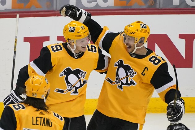 Pittsburgh Penguins' Jake Guentzel celebrates his goal with Sidney Crosby (87) during the third period of an NHL hockey game against the Boston Bruins in Pittsburgh, Sunday, April 25, 2021. The Penguins won 1-0.(AP Photo/Gene J. Puskar)