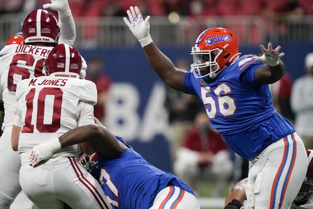Florida defensive lineman Zachary Carter (17) hits Alabama quarterback Mac Jones (10) as Florida defensive lineman Tedarrell Slaton (56) rushes during the first half of the Southeastern Conference championship NCAA college football game, Saturday, Dec. 19, 2020, in Atlanta. (AP Photo/Brynn Anderson)
