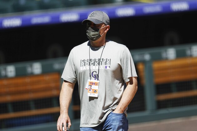 Colorado Rockies general manager Jeff Bridich wears a face mask while observing drills as the baseball team practices in Coors Field, Sunday, July 5, 2020, in Denver. (AP Photo/David Zalubowski)