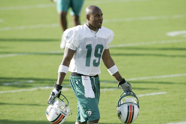 Miami Dolphins wide receiver Ted Ginn carries his and Chris Chambers' helments to the sidelines during the first day of football training camp in Davie, Fla. Saturday, July 28,2007.  (AP Photo/J. Pat Carter)