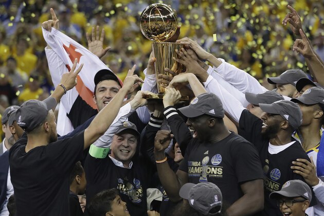Golden State Warriors players, coaches and owners hold up the Larry O'Brien NBA Championship Trophy after Game 5 of basketball's NBA Finals between the Warriors and the Cleveland Cavaliers in Oakland, Calif., Monday, June 12, 2017. The Warriors won 129-120 to win the NBA championship. (AP Photo/Marcio Jose Sanchez)