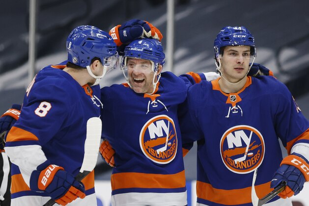 New York Islanders' Andy Greene (4) celebrates with teammates Noah Dobson (8) and Mathew Barzal (13) after scoring against the New York Rangers during the second period of an NHL hockey game Friday, April 9, 2021, in Uniondale, N.Y. (AP Photo/Jason DeCrow)