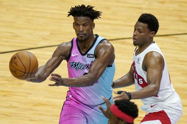 Miami Heat forward Jimmy Butler, left, passes as Toronto Raptors guard Kyle Lowry defends during the second half of an NBA basketball game, Wednesday, Feb. 24, 2021, in Miami. (AP Photo/Lynne Sladky)