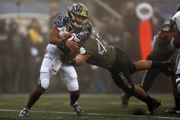 Navy quarterback Xavier Arline (7) is tackled by Army linebacker Jon Rhattigan (47) during the first half of an NCAA college football game Saturday, Dec. 12, 2020, in West Point, N.Y. (AP Photo/Adam Hunger)