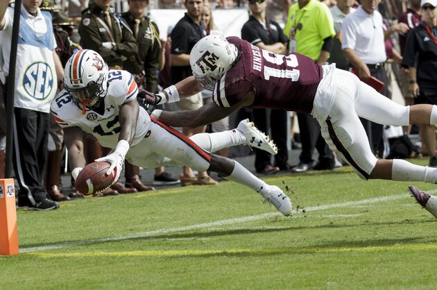 Auburn wide receiver Eli Stove (12) dives for the end zone for a touchdown as Texas A&M linebacker Anthony Hines III (19) defends during the second half of an NCAA college football game on Saturday, Nov. 4, 2017, in College Station, Texas. (AP Photo/Sam Craft)